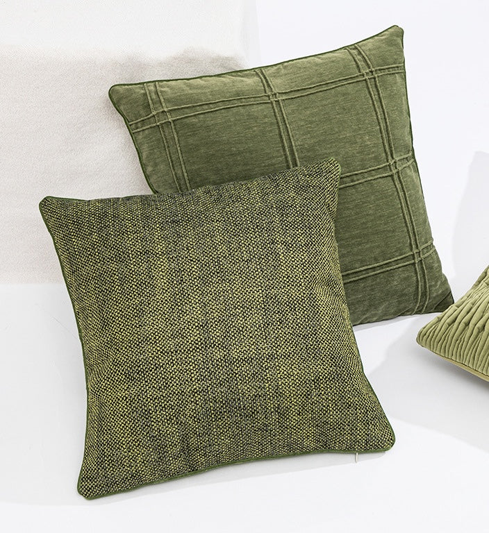Two green textured pillows on a white background