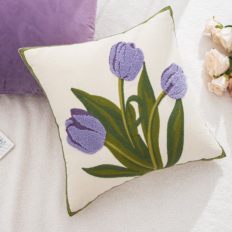 Decorative pillow with tufted purple tulips on a soft surface