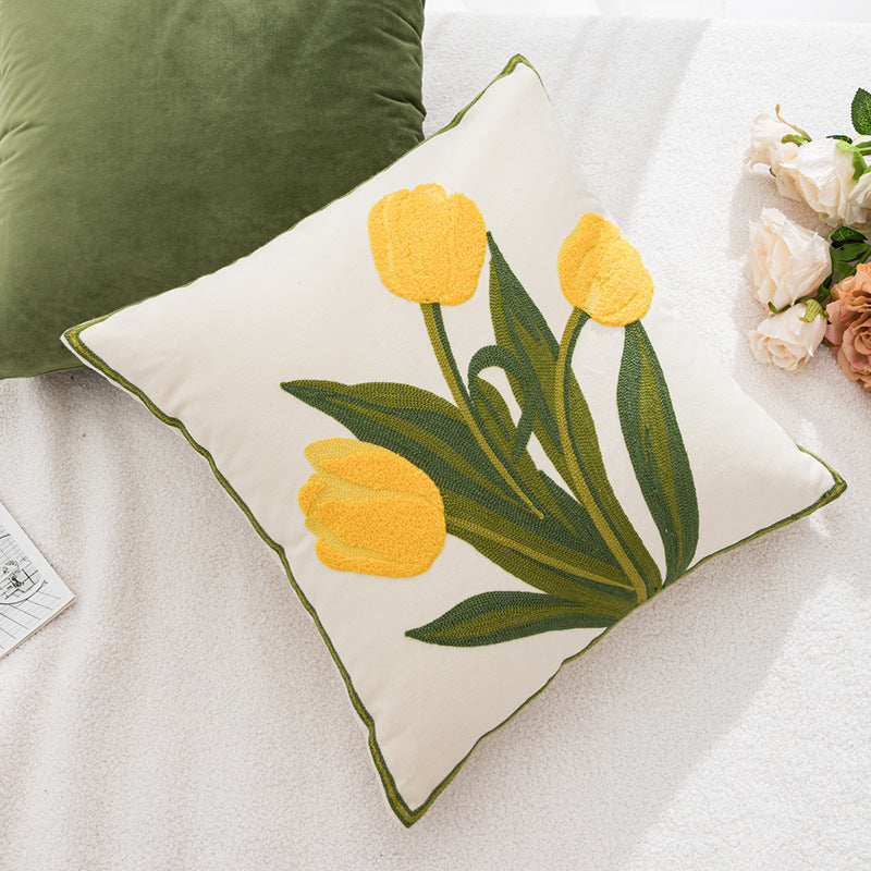 Decorative pillow with yellow tulip design on a white surface