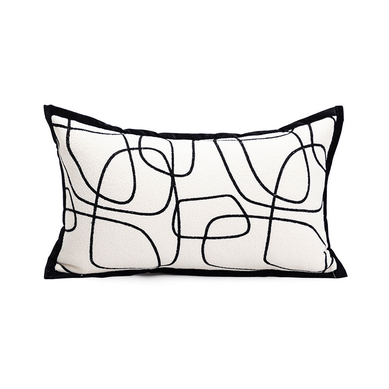 Decorative pillow with abstract black line design on a white background