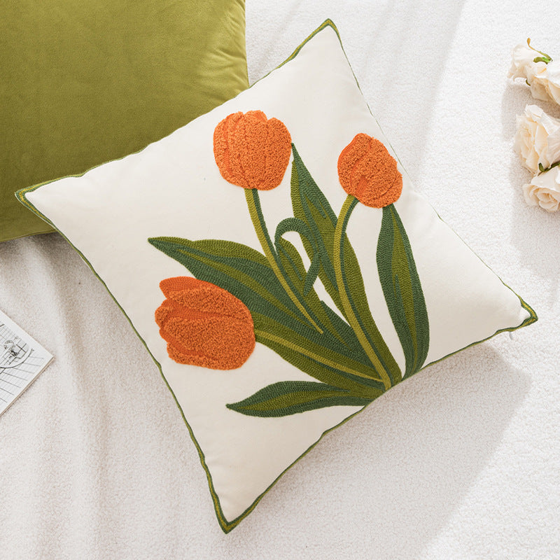 Decorative pillow with orange tulip design on a soft surface