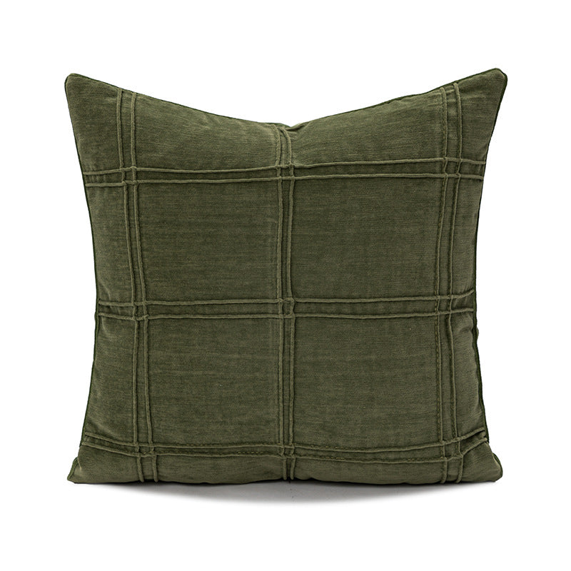 Green pillow with woven pattern on a white background