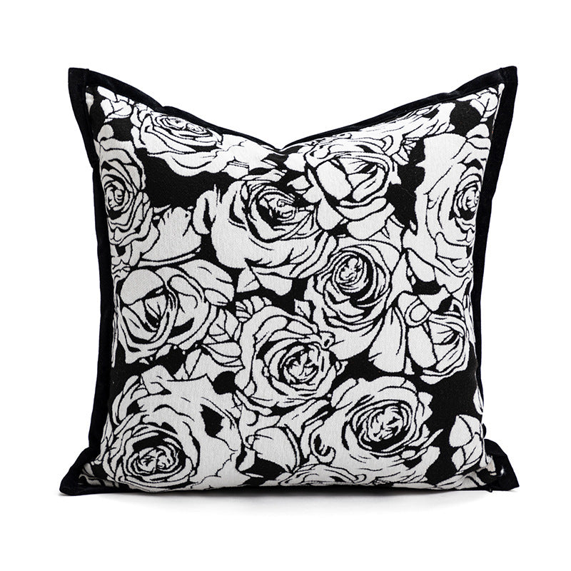 Decorative pillow with black and white rose pattern on a white background