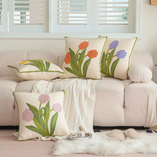 Tufted decorative pillows with floral patterns on a couch in a living room setting.