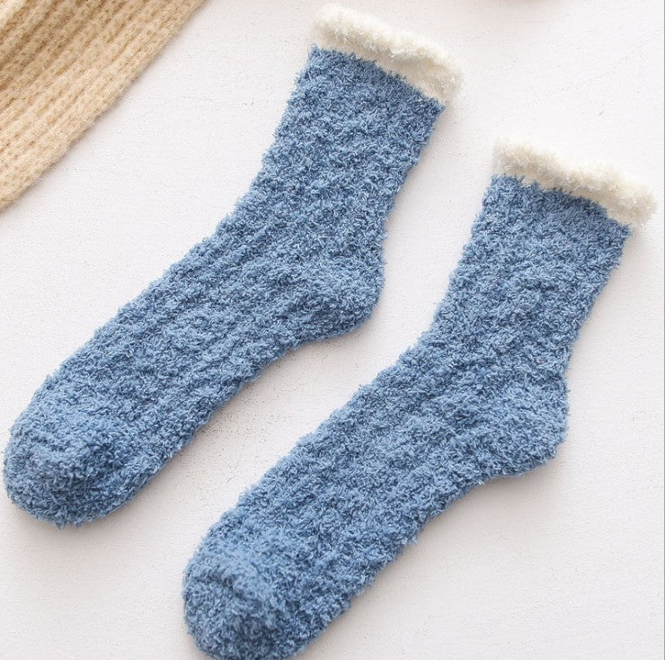 Pair of blue fuzzy socks with white trim on a light background