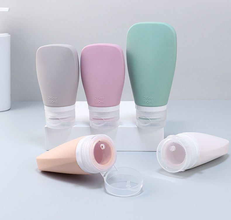Set of colorful travel-sized bottles on a light gray background