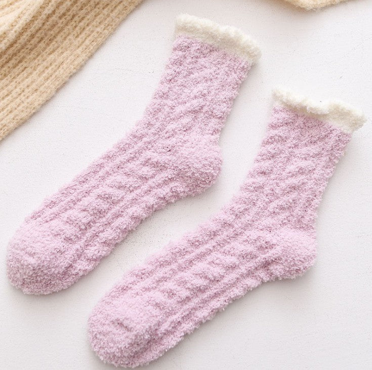 Pair of purple fuzzy socks on a light background